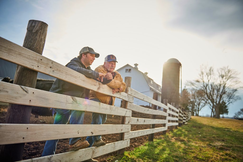 Healthcare advertising photography of farmers leaning on fence